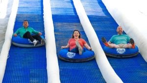 two men and one woman sliding